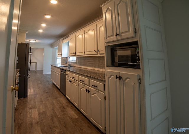 kitchen with dark hardwood / wood-style floors, sink, white cabinets, dark stone counters, and stainless steel appliances