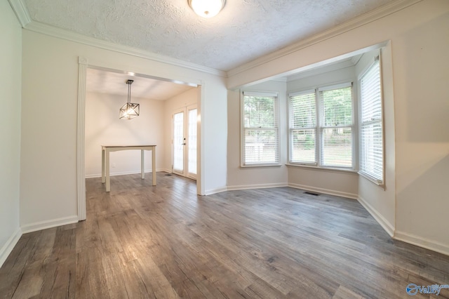 empty room with ornamental molding, dark hardwood / wood-style floors, a textured ceiling, and french doors