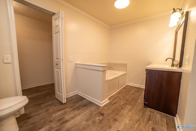 bathroom with vanity, a bath, wood-type flooring, and ornamental molding