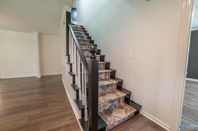 stairs with wood-type flooring and crown molding