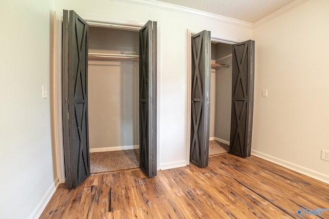 unfurnished bedroom featuring crown molding and wood-type flooring