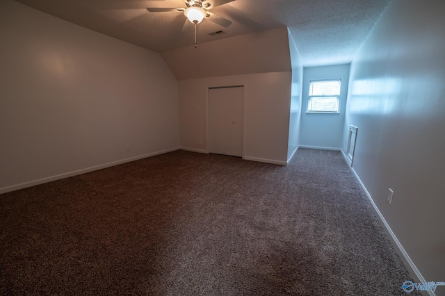 additional living space with lofted ceiling, ceiling fan, a textured ceiling, and carpet