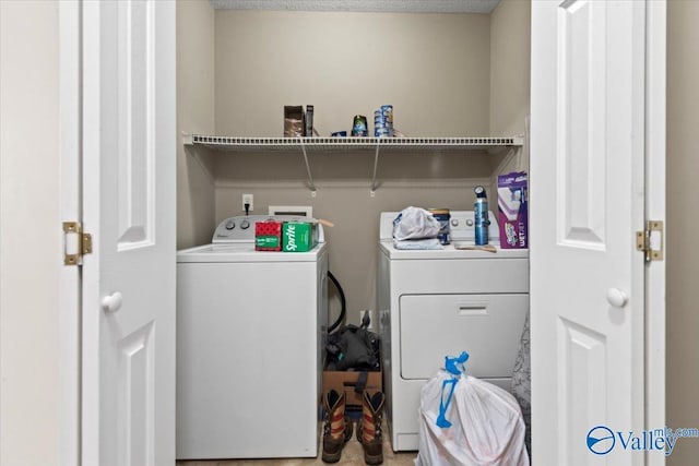 laundry room featuring laundry area, a textured ceiling, and washer and dryer