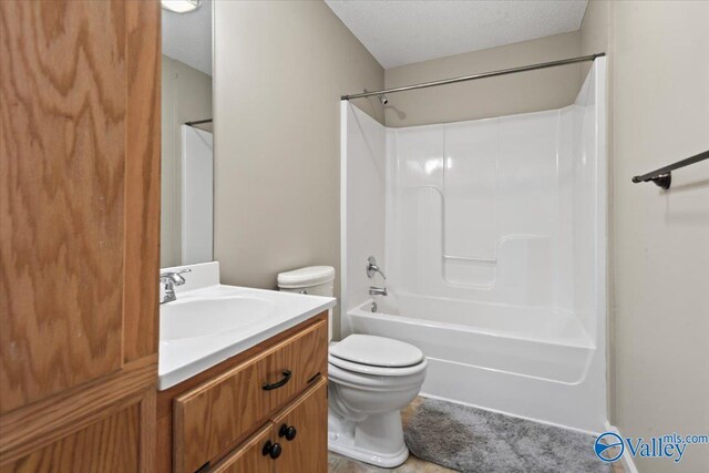 full bathroom featuring toilet, shower / washtub combination, a textured ceiling, and vanity