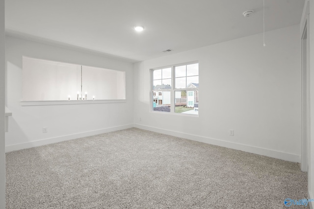 spare room featuring an inviting chandelier and carpet