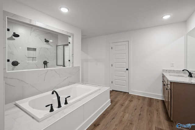 bathroom featuring independent shower and bath, vanity, and hardwood / wood-style flooring