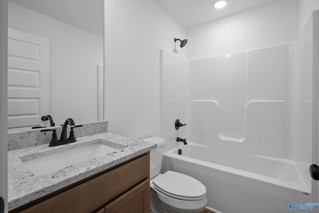 full bathroom featuring washtub / shower combination, vanity, and toilet