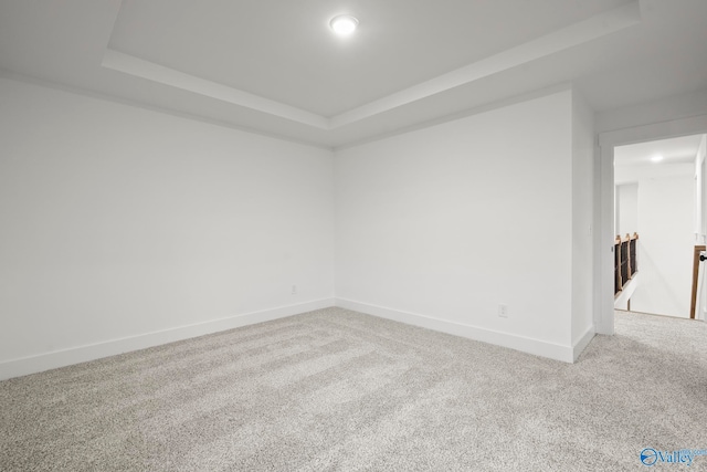 carpeted empty room with a tray ceiling