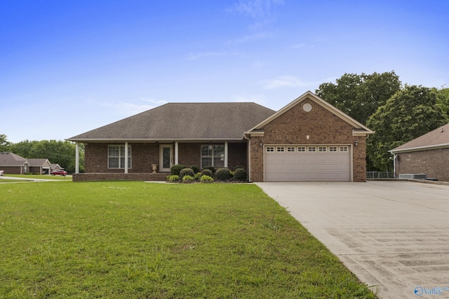 16121 Kyle Moran Dr, Athens, AL 35614 - view of front of house with an attached garage, a front yard, driveway, brick siding, and roof with shingles