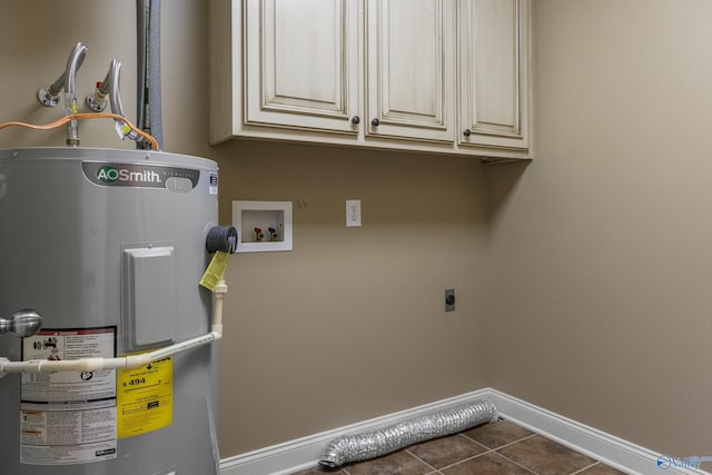 16121 Kyle Moran Dr, Athens, AL 35614 - laundry room with electric dryer hookup, water heater, cabinet space, baseboards, and dark tile patterned flooring