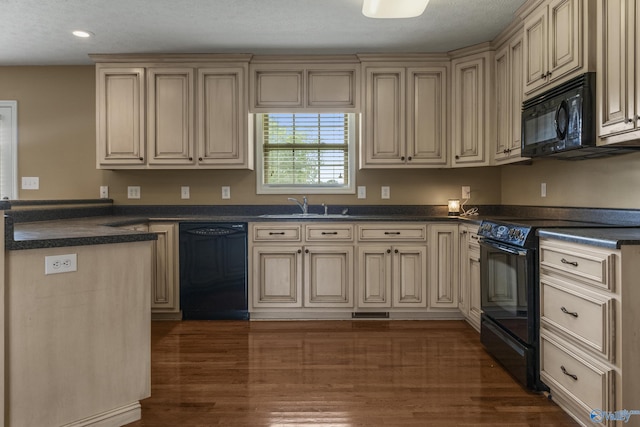 16121 Kyle Moran Dr, Athens, AL 35614 - kitchen featuring black appliances, cream cabinets, a sink, dark countertops, and recessed lighting
