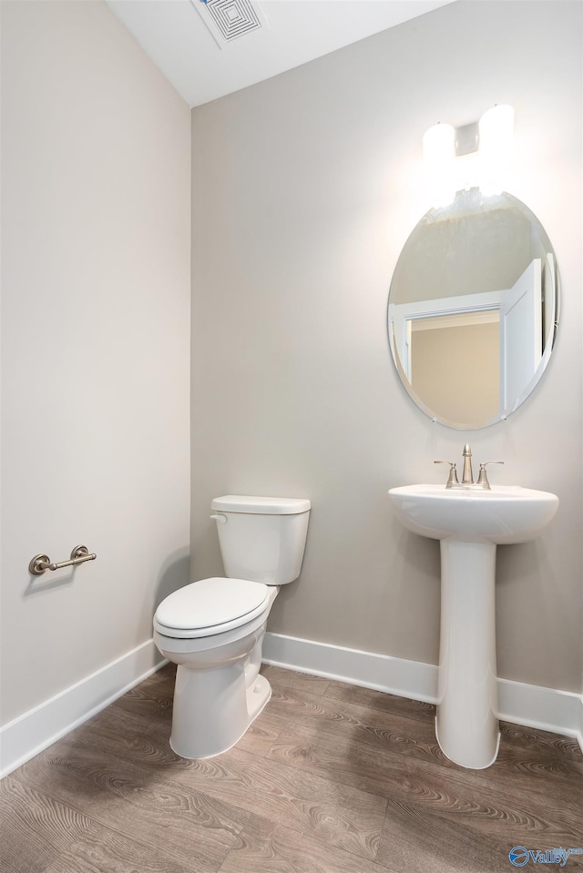 bathroom with sink, toilet, and hardwood / wood-style floors