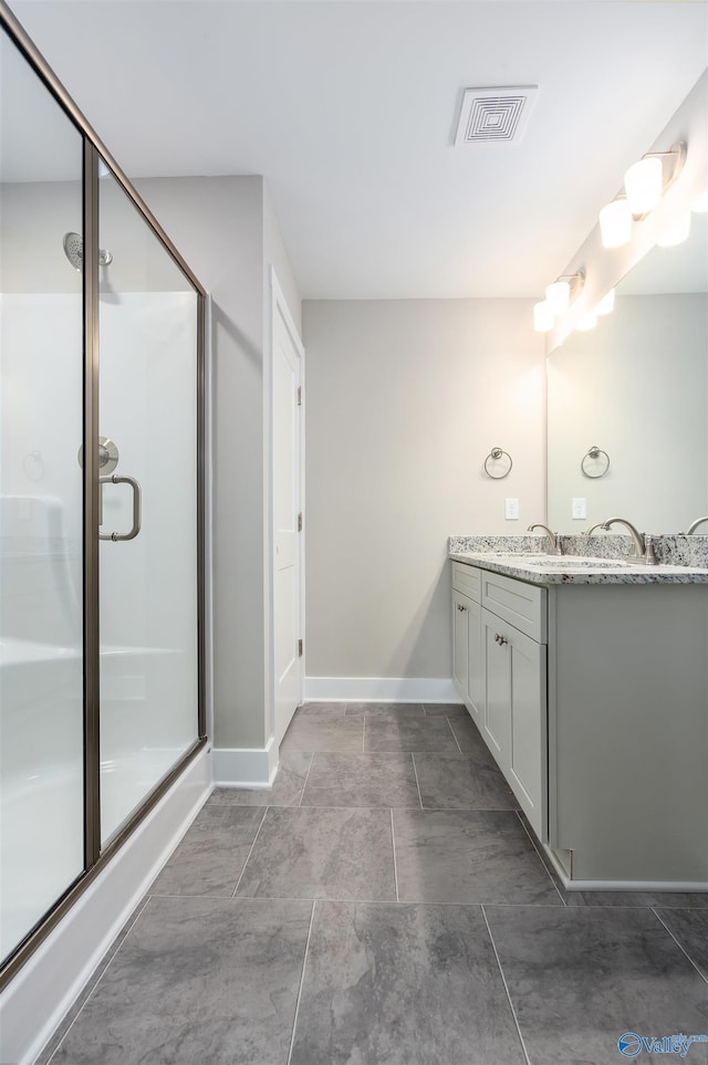 bathroom with a shower with door and vanity