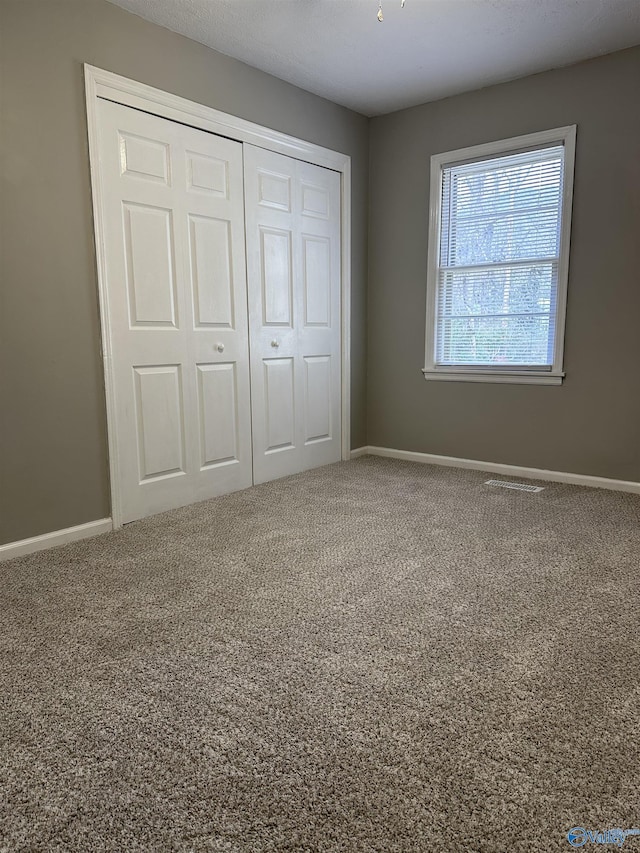 unfurnished bedroom with carpet floors and a closet