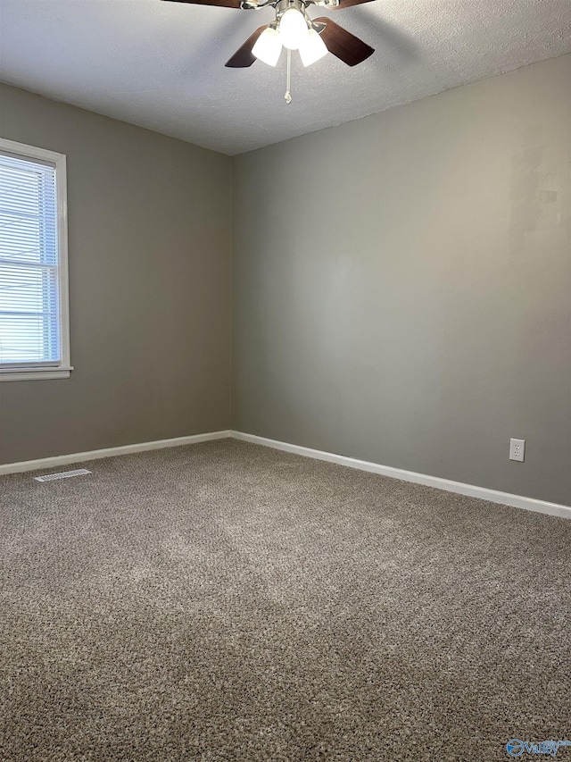 carpeted empty room with ceiling fan and a textured ceiling