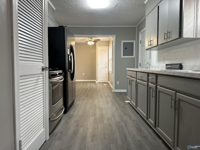 kitchen with decorative backsplash, gray cabinets, stainless steel range oven, and hardwood / wood-style floors