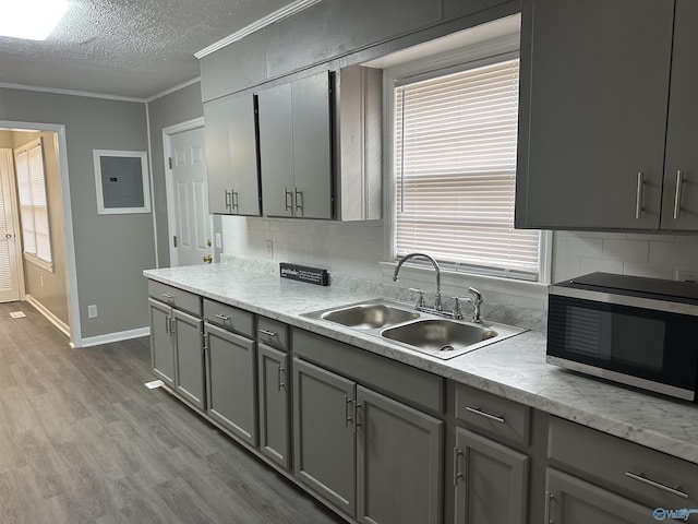 kitchen with ornamental molding, sink, and gray cabinetry