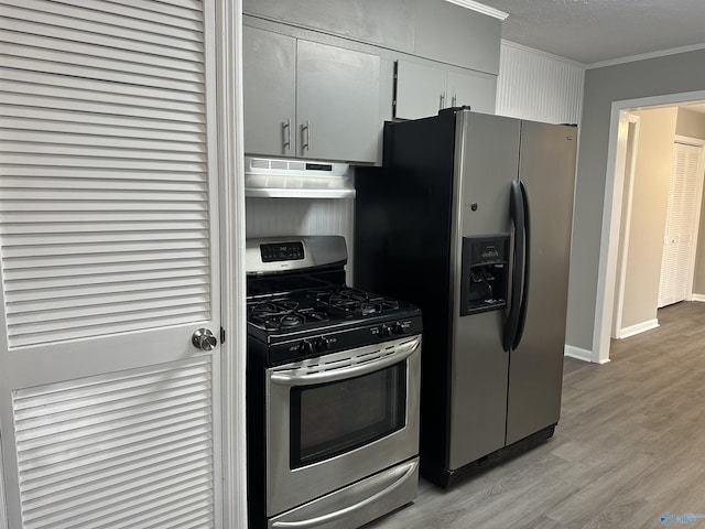 kitchen featuring crown molding, appliances with stainless steel finishes, light hardwood / wood-style flooring, and a textured ceiling