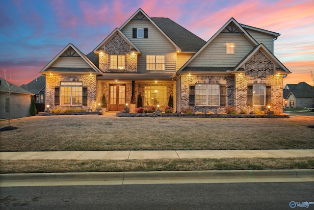 craftsman inspired home featuring a front yard and brick siding
