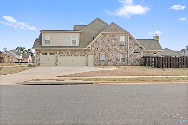 view of front facade with a garage, fence, concrete driveway, brick siding, and a gate