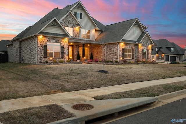 craftsman-style house with a front yard, brick siding, and roof with shingles