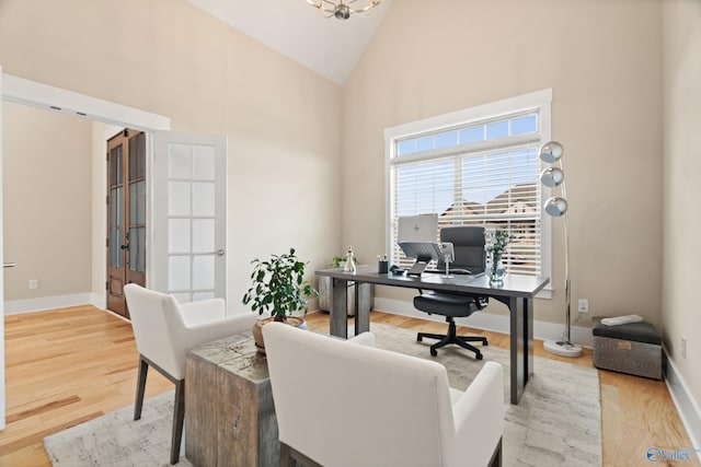 office featuring a chandelier, wood finished floors, high vaulted ceiling, and baseboards