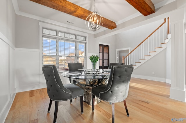 dining space with visible vents, an inviting chandelier, beam ceiling, stairway, and wood finished floors