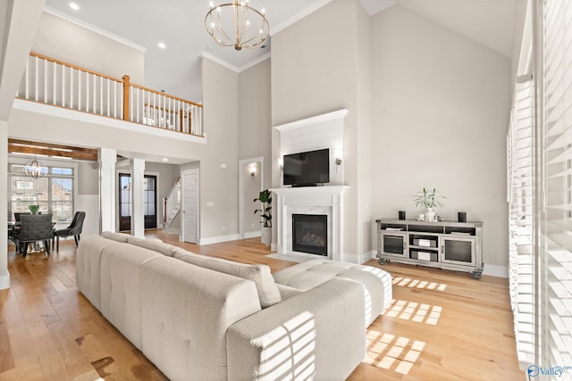 living room with stairway, a notable chandelier, a fireplace, and light wood finished floors