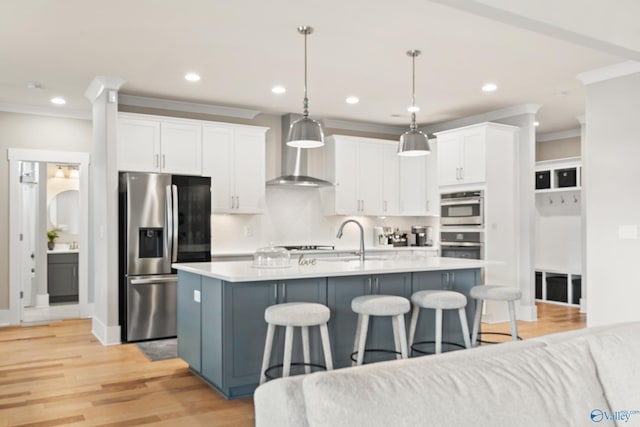 kitchen with a sink, crown molding, white cabinetry, stainless steel appliances, and a breakfast bar area