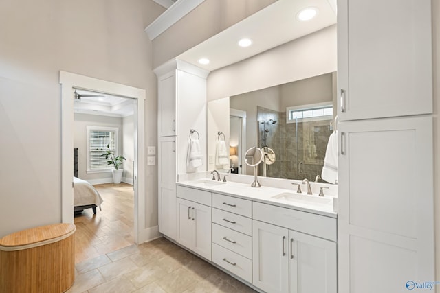 full bathroom featuring a stall shower, double vanity, a sink, and recessed lighting