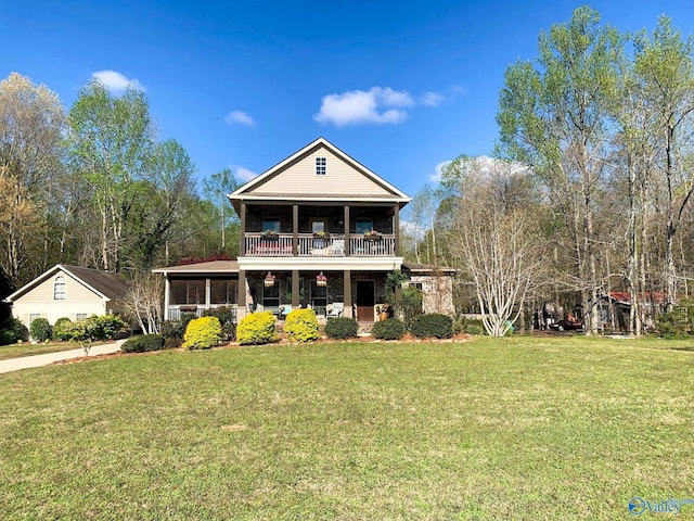 view of front facade featuring a balcony and a front yard