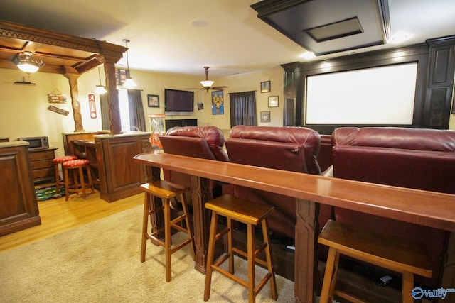 cinema room with light wood-type flooring and ceiling fan