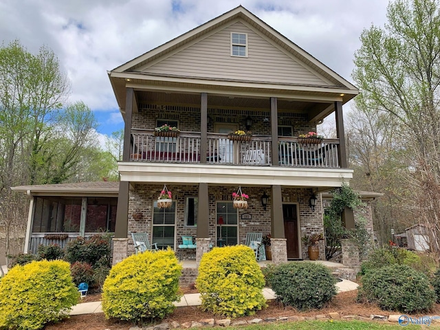 view of front of house featuring brick siding, a porch, and a balcony