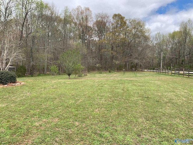 view of yard featuring fence and a view of trees