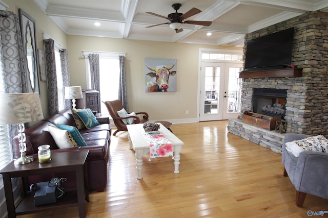 living room featuring a fireplace, light hardwood / wood-style floors, beam ceiling, ceiling fan, and coffered ceiling