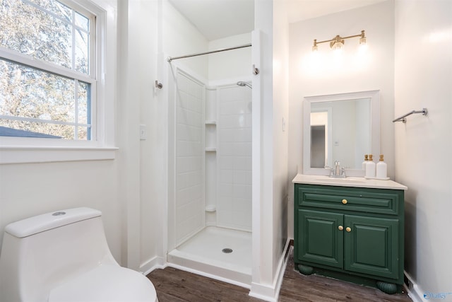 bathroom with a shower, hardwood / wood-style floors, vanity, and toilet