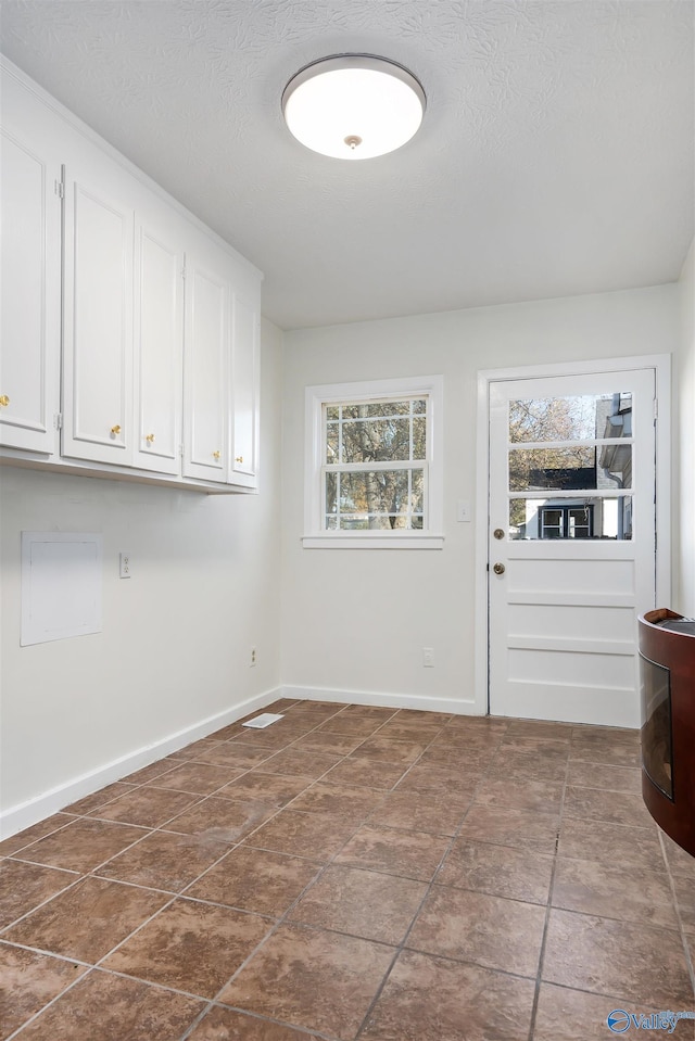 interior space featuring cabinets and a textured ceiling