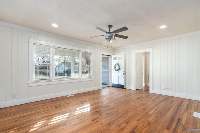 interior space featuring wood-type flooring, ceiling fan, and crown molding