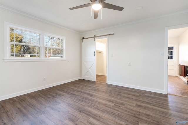 unfurnished bedroom featuring a barn door, ceiling fan, dark hardwood / wood-style flooring, and crown molding