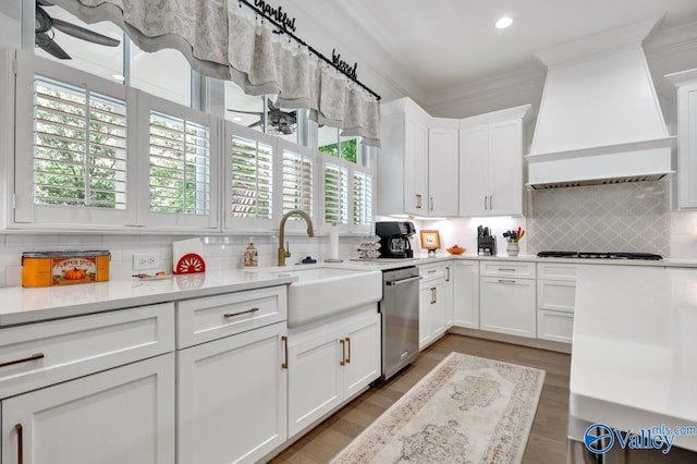 kitchen with ornamental molding, gas cooktop, custom range hood, a sink, and dishwasher
