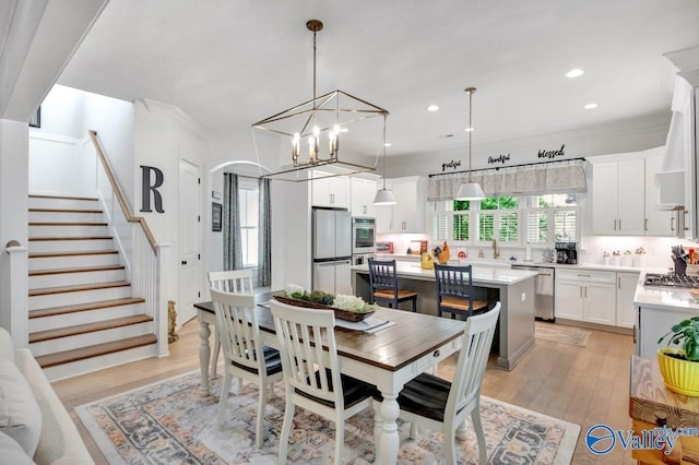 dining area with crown molding, an inviting chandelier, light wood finished floors, stairs, and recessed lighting