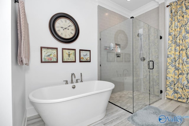 full bathroom with a freestanding bath, a shower stall, wood finished floors, baseboards, and ornamental molding