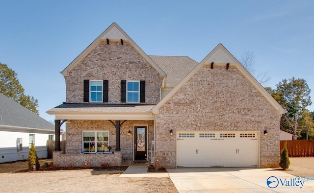 view of front facade featuring driveway, fence, and brick siding