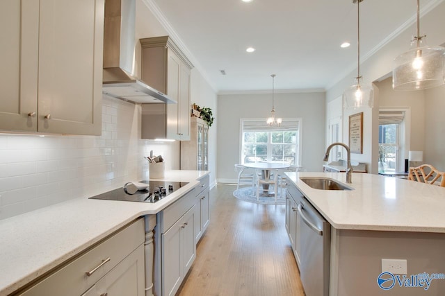 kitchen featuring crown molding, light wood-style floors, a sink, dishwasher, and wall chimney exhaust hood