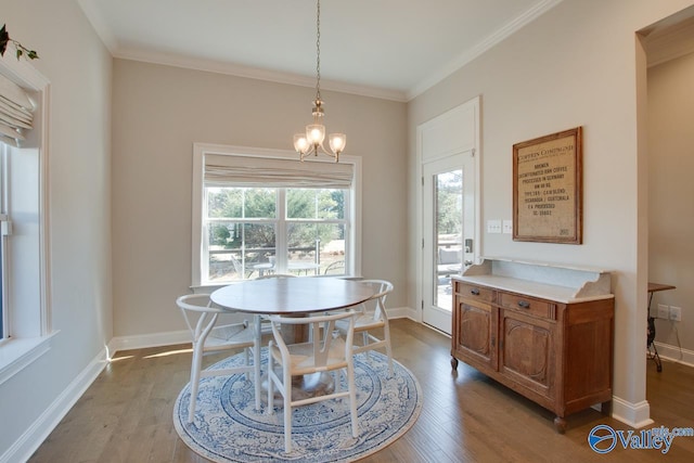 dining room with ornamental molding, wood finished floors, and baseboards