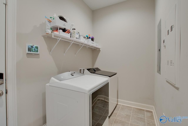 laundry area featuring light tile patterned flooring, separate washer and dryer, laundry area, electric panel, and baseboards