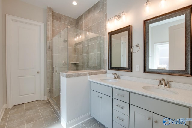 bathroom with double vanity, tile patterned flooring, a sink, and a shower stall