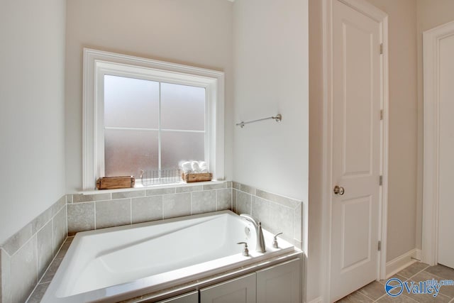 bathroom with a garden tub and tile patterned floors