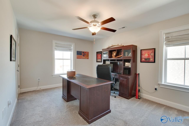 home office with light carpet, a healthy amount of sunlight, baseboards, and visible vents