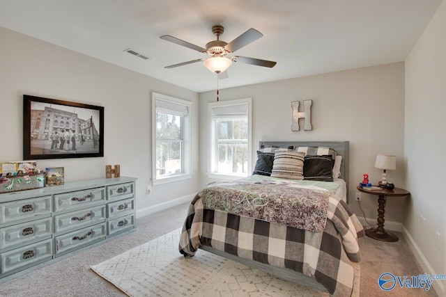 carpeted bedroom featuring baseboards, visible vents, and ceiling fan